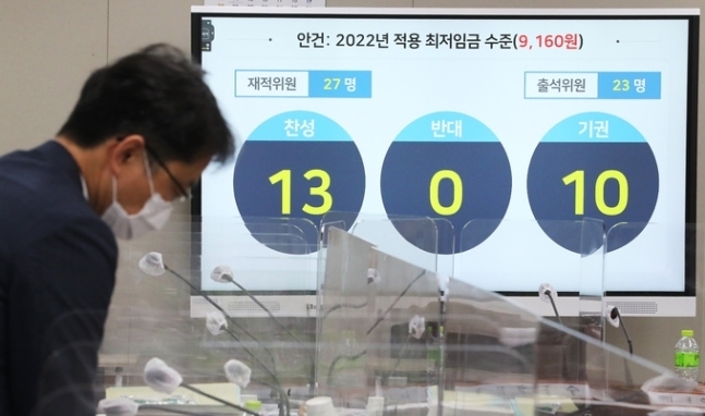 박준식 최저임금위원회 위원장(오른쪽)이 12일 밤 제9차 전원회의에서 내년도 최저임금을 9천160원으로 의결한 뒤 위원들과 대화하고 있다.(연합뉴스)