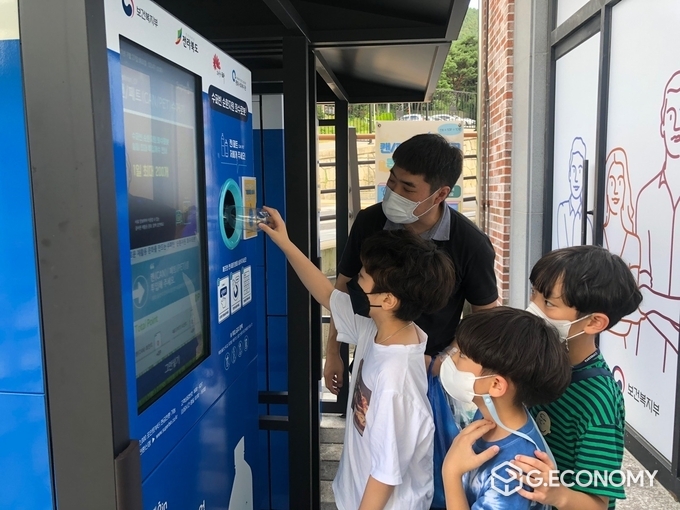 평화동에 설치된 순환자원 회수로봇 네프론 앞에서 어린이들이 폐페트병을 투입하며 관심어린 눈빛으로 바라보고 있다. 사진=전주시청