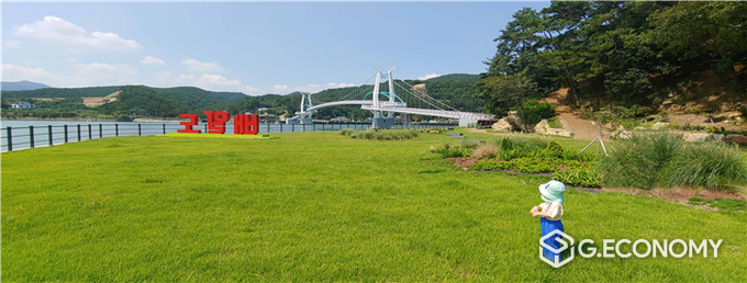 사진=배알도 섬 정원에서 놀던 아이가 멀리 ‘배알도 별 헤는 다리’ 를 바라보고 있다.