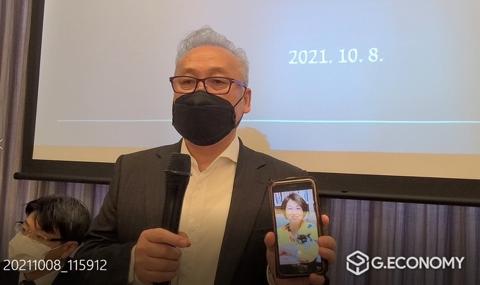 기자회견에서 고)박씨의 남편 오 씨는 핸드폰 속에 아내의 사진을 보여주며 억울한 사연을 전달하고 있다.