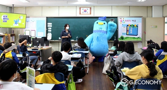 신성 새마을금고 금융강사와 캐릭터 '블루 대장'이 인천의 한 초등학교 학생들에게 금융교육 행사를 가지고 있다/새마을금고 제공
