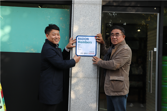 김우식 페인트앤홈 대표, 조승연 연세대학교 라돈안전센터장이 라돈안전마크를 부착하고 있다. 