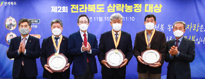 15일 도청 중회의실에서 열린 제2회 전라북도 삼락농정 대상 시상식에 송하진도지사가 농업‧농촌 가치 제고에 공헌한 수상자에게 상패를 수여하고 기념촬영을 하고 있다. 왼쪽부터 김철수 전북도의회 농산경위 위원장, 이기성 보람찾는 농민대상, 송하진 도지사, 진안군 원연장마을(박명진 이장) 사람찾는 농촌대상, 서재필 제값받는 농업대상, 이상철 삼락농정 위원회 민간 위원장 (사진=전북도청)
