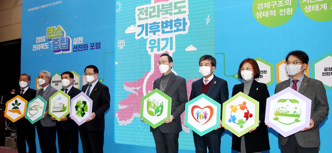 1일 도청 대회의실에서 열린 ‘2050 전라북도 탄소중립 실현 선진화 포럼'에 송하진 도지사를 비롯해 14개 시장‧군수, 분야별 민간 대표등 참석자들이 탄소중립 실현을 위한 상쇄, 도약, 포용의 3대 정책 전략과 9개 과제를 실현하겠다는 퍼포먼스를 갖고 있다.(사진=전북도청)