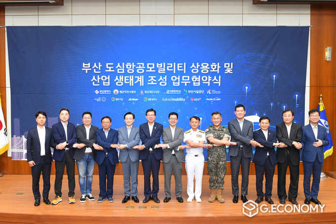 27일 오후 부산광역시청 국제회의장에서 열린 UAM 상용화 업무협약식에서 (왼쪽부터) 파블로항공 정덕우 운영이사 / LG유플러스 이상엽 전무 / 유승일 카카오모빌리티 부사장 / GS칼텍스 장인영 사장 / 제주항공 김이배 대표이사 / 박형준 부산광역시장 / 박일평 LG사이언스파크 대표 / 해군작전사령부 강동훈 사령관 / 육군53사단장 여인형 사단장 / GS건설 허윤홍 사장 / 한국해양대 도덕희 총장 / 부산시설공단 이해성 이사장 / 부산테크노파크 김형균 원장이 기념촬영을 하고 있는 모습(사진=LG유플러스)