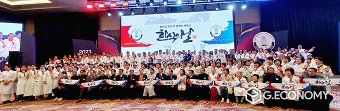 한한국 세계평화작가가 친필휘호로 쓴 ‘한식을 문화로 경제로 세계로, 한식의 날_ 비전문구 타월을 들고 단체기념 촬영을 하고 있다