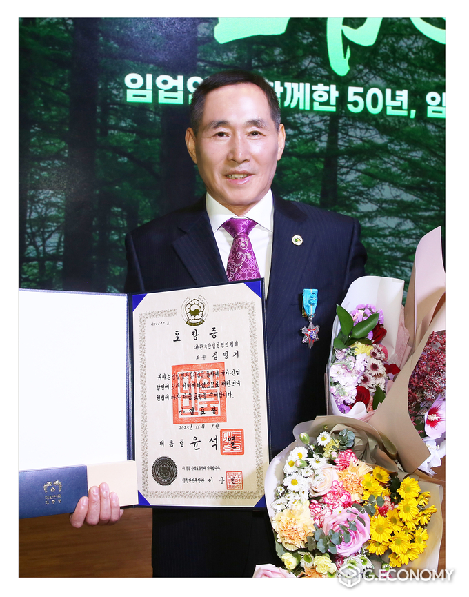 김명기씨가 정부산업포장을 받고 기념촬영을 하고 있다.