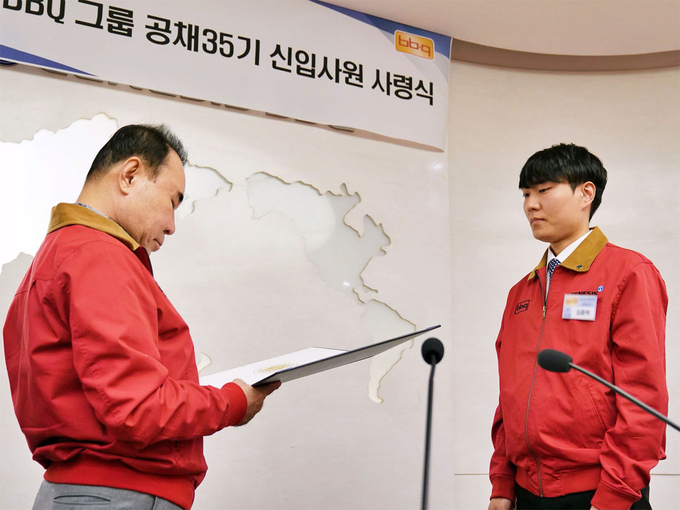 윤홍근 제너시스BBQ 그룹 회장(왼쪽)이 2023 하반기 공개채용 신입사원에게 사령장을 수여하고 있다. 사진=제너시스BBQ 그룹 제공