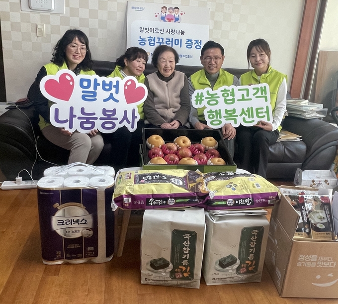 김성훈 고객행복센터 센터장(오른쪽에서 두 번째)과 말벗어르신(가운데)을 비롯한 참여자들이 30일 진행한 우리농산물 꾸러미 나눔행사에서 기념촬영을 하고 있다. 사진=NH농협은행