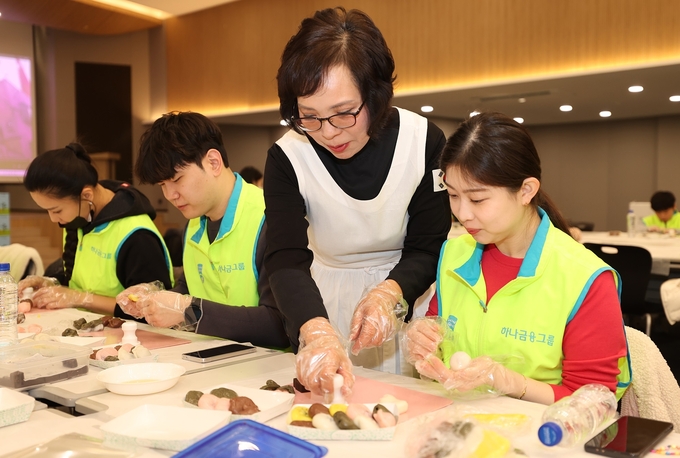 4일 열린 ‘설날맞이 사랑의 떡 나눔 봉사활동’에 참석한 하나금융그룹 임직원 및 가족들이 우리나라 전통떡인 '바람떡'과 '꽃산병'으로 구성된 떡 세트를 만들고 있다. 사진=하나금융그룹