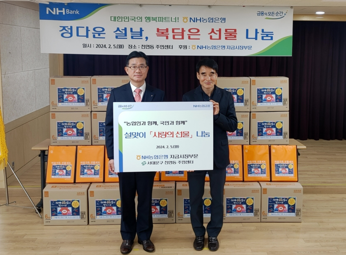 5일 서울 서대문구 천연동 주민센터에서 열린 ‘설맞이 사랑의 선물 나눔행사’에서 농협은행 서준호 부행장(좌측)과 유명선 천연동장이 기념촬영을 하고 있다. 사진=NH농협은행 제공