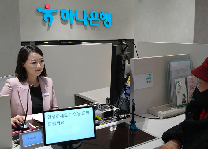 ‘시니어 특화점호’ 직원이 어르신들을 대상으로 편리한 금융업무 상담을 지원하기 위해 ‘글로 보는 상담 서비스’를 제공하고 있는 모습. 사진=하나은행 제공