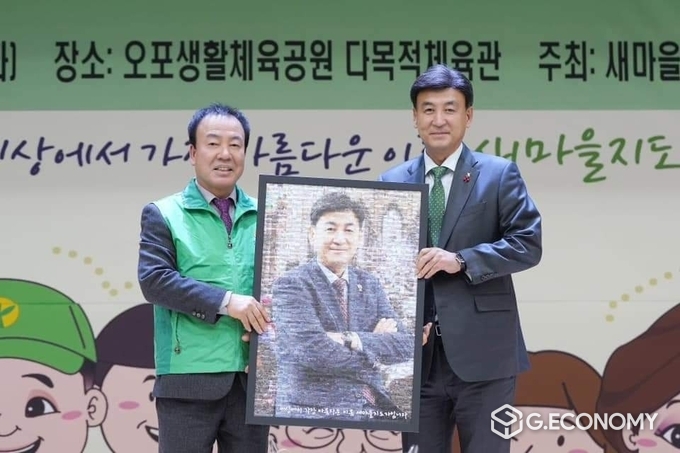 2023년 새마을지도자 송년회 자리에서 박광성 지회장(좌)이 방세환 시장(우)에게 감사의 선물을 증정하고 있다.