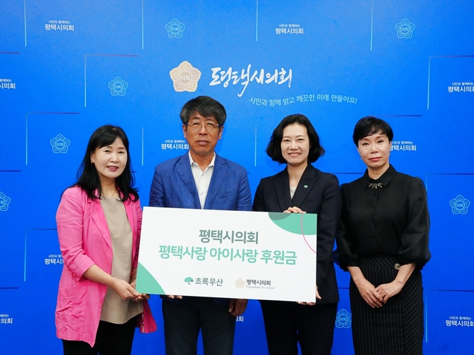 유승영 평택시의회 의장이 29일 시의회 간담회장에서 초록우산 어린이재단에 후원금을 전달한 후 관계자들과 함께 기념촬영을 하고 있다./ 평택시의회 제공