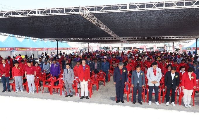 지난 18일, 섬 낙지축제 참석자들이 5·18 민주화운동 민주 영령들에 대한 경례와 묵념을 하고 있다.