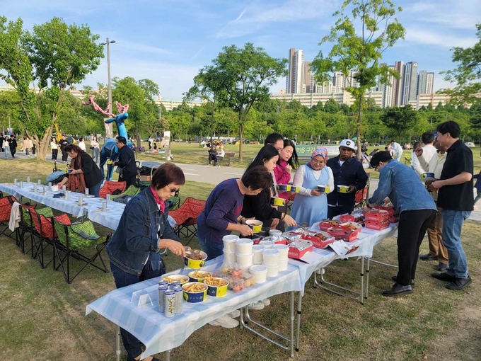 K-치킨을 맛보기 위해 한국을 찾은 말레이시아 유튜버들이 반포 한강공원 달빛 무지개 분수 인근에서 BBQ 치맥을 즐기고 있다