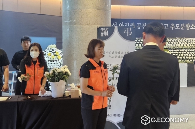 화성 아리셀 공장 화재 사고 극복을 위한 자원봉사자가 화성시청 로비에 마련된 합동 분양소에 방문한 시민에게 국화꽃을 전달하고 있다./사진=화성시