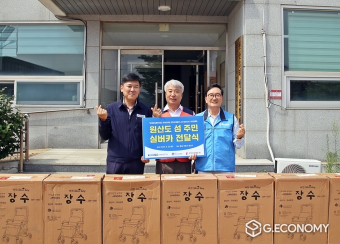 한전산업개발 함흥규 사장(가운데)과 한국해양교통안전공단 김준석 이사장(좌측), 한국섬진흥원 오동호 원장(우측)이 실버카를 전달하며 원산3리복지회관 앞에서 기념촬영을 하고 있다.