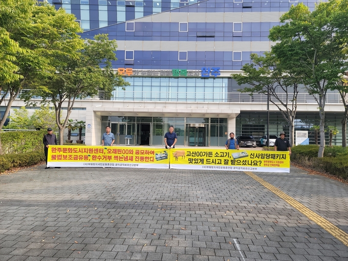 ㈔부패방지국민운동총연합 회원들이 완주군청 정문 앞에서 현수막을 펼치고 시위하고 있다. (사진= 부패방지 제공)