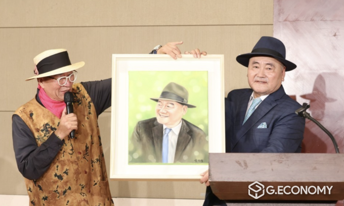 태산 배광주 회장 ‘풍운아’ 북 콘서트장에서 유퉁의 큰 누님 유은영 선물한 신지영 작가의 배광주 회장 초상화 전달하고 있다./뉴스아이이에스