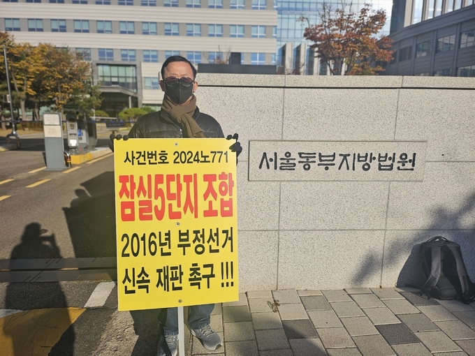 조합원 A씨가 팻말을 들고 재판 촉구 시위를 하고 있다. 
