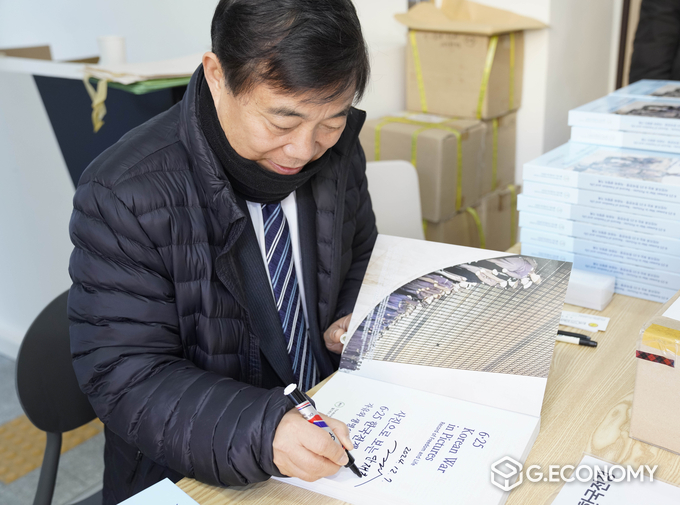 안재철 월드피스프리덤유나이티드 대표가 출판기념회 사전행사로 싸인회를 진행 중이다. 