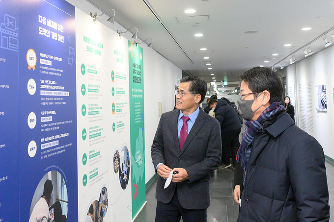 약자동행 지원사업 우수사례 홍보 전시물을 보고 있는 이기재 구청장