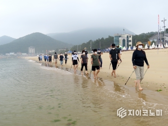 전남 완도군 해양치유 프로그램 참가자들이 신지 명사십리해수욕장에서 해변 노르딕워킹을 즐기며 건강한 여유를 만끽하고 있다. 완도군 제공
