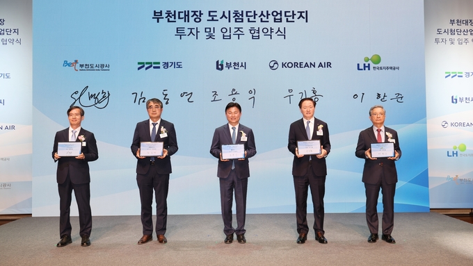 조용익 부천시장(가운데)을 비롯한 부천도시공사-경기도-부천시-대한항공-한국토지주택공사(LH) 등 5개 기관 대표자들이 서명을 마친 후 협약서가 담긴 태블릿을 들고 기념 촬영을 하고 있다. (사진=부천시)