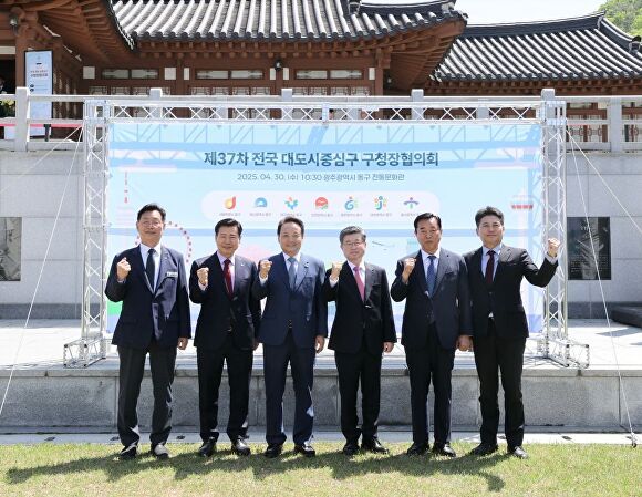 30일 광주 동구에서 진행된 제37차 전국 대도시중심구 구청장협의회에서 참여한 도시의 중심구 구청장들이 현수막 앞에서 파이팅을 하고 있다. 동구 제공