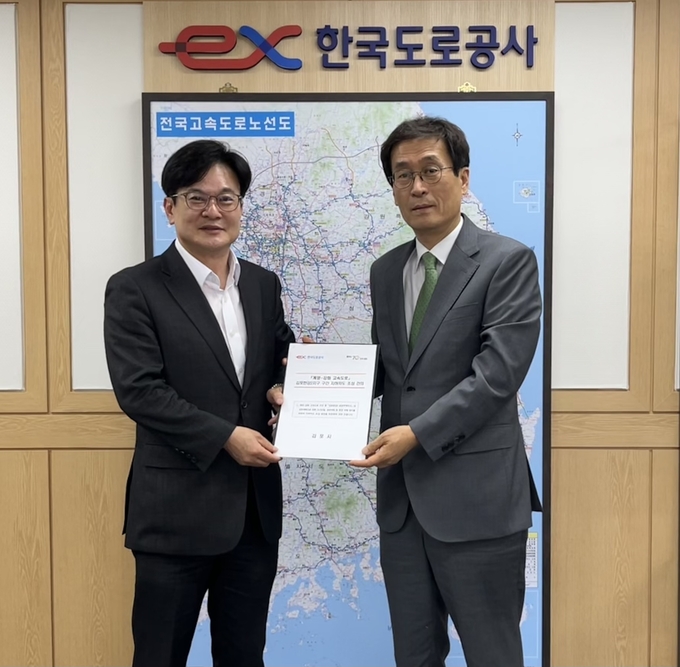 김병수(왼쪽) 시장이 함진규 한국도로공사 사장에게 건의문을 전달한 뒤 기념 촬영을 하고 있다. (사진=김포시)