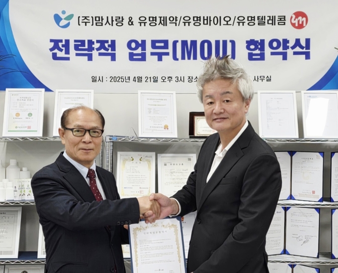 ㈜맘사랑 신승용 대표(오른쪽)와 유명제약·유명바이오·유명텔레콤 김유명 회장(왼쪽)이 전략적 업무협약(MOU)을 체결한 뒤 기념촬영을 하고 있다.