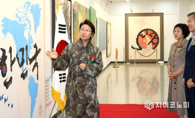 한한국 세계평화작가가 내빈들 앞에서 작품을 설명하고 있다(사진제공=세계평화사랑연맹)