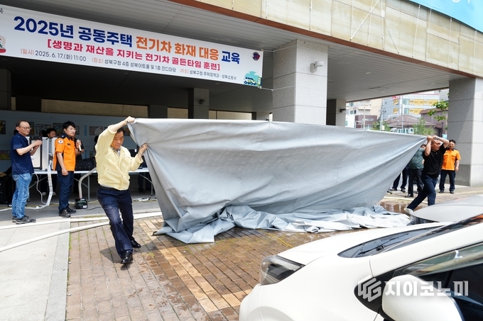 성북구청 1층 잔디마당에서 진행한 전기차 화재 진압 실습에서 이승로 성북구청장(왼쪽)이 질식소화포를 이용해 화재에 대응하고 있다