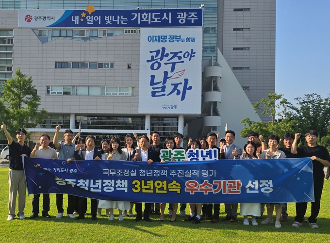 강기정 광주광역시장이 지난 27일 시청 앞 잔디광장에서 ‘2024년 청년정책 추진실적 평가’ 3년 연속 우수기관 선정을 축하하며 직원들과 기념촬영을 하고 있다. 광주광역시 제공