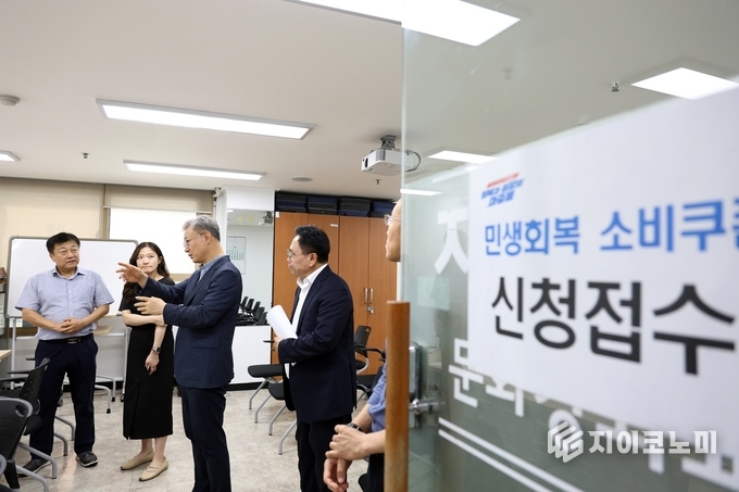 장인홍 구로구청장(왼쪽 세 번째)이 21일 민생회복 소비쿠폰 접수창구를 찾아 현장 상황을 점검하며 관계자들과 의견을 나누고 있다.