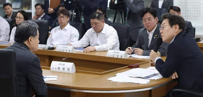 “나도 산업재해 피해자” 이재명 대통령이 25일 경기 시흥시 SPC 삼립 시흥 공장에서 열린 산업재해 근절 현장 노사간담회에서 허영인 SPC그룹 회장(왼쪽)과 대화를 나누고 있다. 이 대통령은 “똑같은 현장에서 똑같은 방식으로 똑같은 사고가 반복되는 건 문제가 있다”며 잇달아 사망 사고가 발생한 SPC를 질타했다. 시흥=대통령실사진기자단