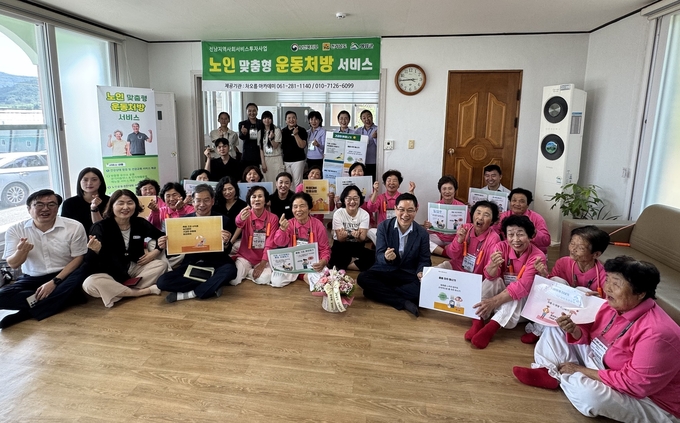 서호면 남하동경로당을 방문한 영암군과 전남도 관계자들이 운동처방 서비스 현장을 점검한 뒤 어르신들과 함께 기념촬영을 하고 있다. 영암군 제공