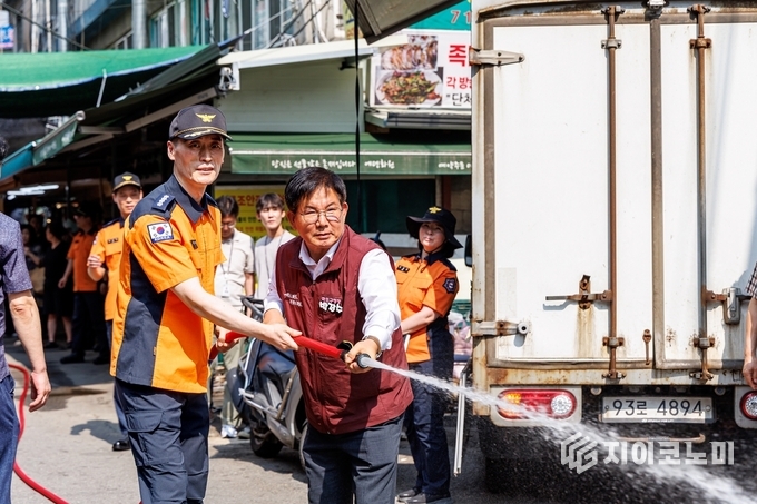 박강수 마포구청장이 마포소방서 관계자와 함께 비상소화장치 작동을 시연하고 있다.