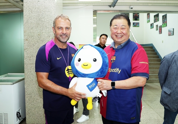 김경일 파주시장이 FC바르셀로나 선수단 방문을 축하하며 시 마스코트 파랑이 인형을 한지 플릭 감독에게 전하고 있다. (사진=파주시)