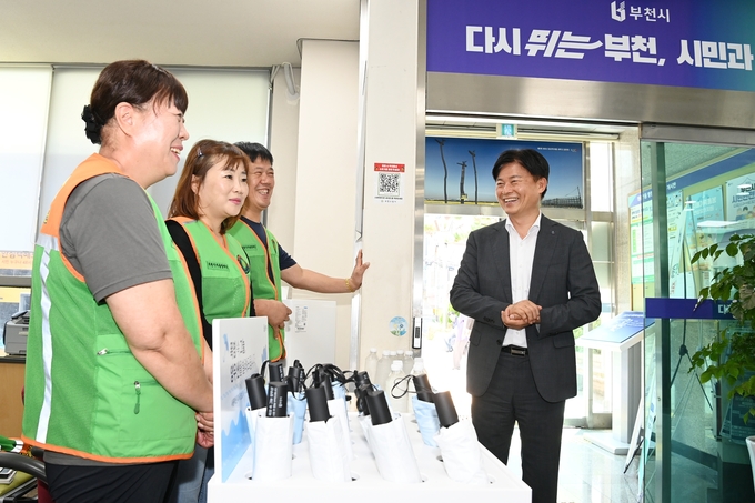 조용익 부천시장이 원종1동 행정복지센터를 찾아 양우산 대여 봉사를 하고 있는 자율방재단에게 격려의 말을 전하고 있다. (사진=부천시)