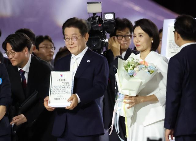 이재명 대통령이 15일 서울 종로구 광화문광장에서 열린 광복 80년, 국민 주권으로 미래를 세우다 제21대 대통령 국민임명식에서 국민 대표 80인이 참여한 임명장을 전달받고 있다. 