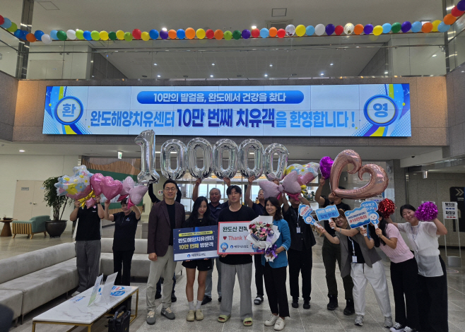 완도해양치유센터 10만 번째 치유객 김아로 씨, 전복 세트와 초대권 경품 수령하며 기념 촬영. 완도군 제공