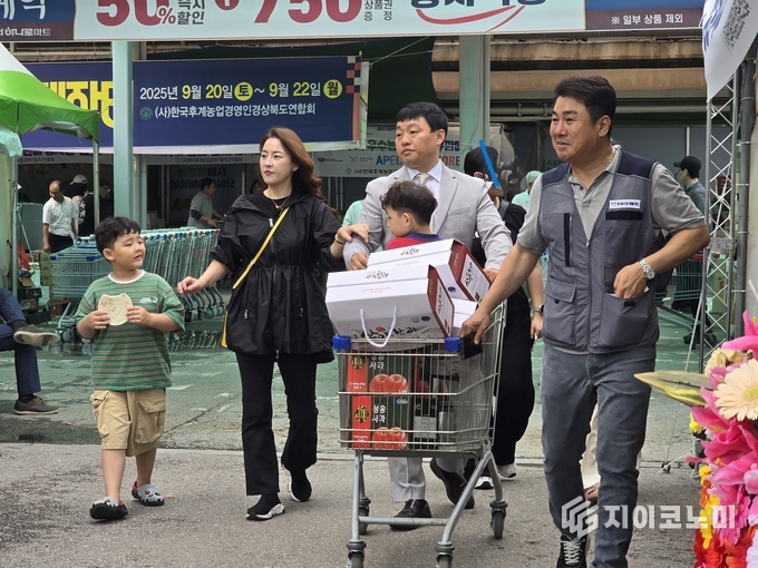 농협 성남유통센터 “2025 경상북도 농특산물 직거래장터”를 찾은 조성원씨 가족을 안내하고 있는 한재산업개발 여인현 대표/뉴스아이이에스