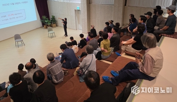 지난 21일 성북구 공백공유에서 열린 설명회에서 김계숙 교수가 정릉골 재개발 조합의 문제점을 짚으며 조합원 백여 명과 의견을 나누고 있다.