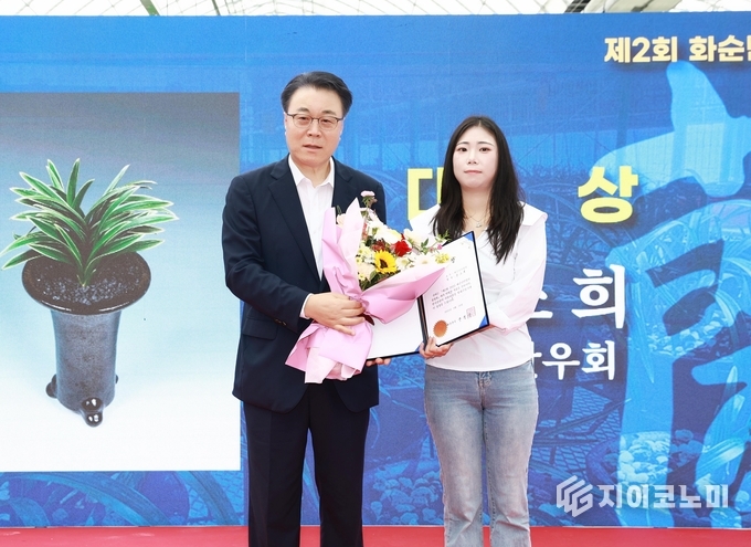 구복규 화순군수가 대상 수상자인 윤소희 씨(화순난우회)에게 상을 수여한 뒤, 단엽복륜 ‘신라’를 배경으로 기념사진을 찍고 있다. 화순군 제공