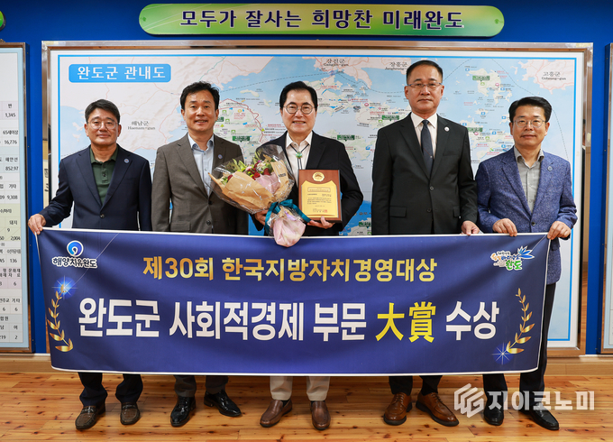 신우철 완도군수가 군수실에서 제30회 한국지방자치경영대상 사회적 경제 부문 대상 수상 소식을 전하며 관계자들과 기념촬영을 하고 있다. 완도군 제공