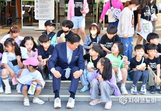 김한종 장성군수가 지난해 봄 군청사 앞에서 장성중앙초등학교 학생들과 담소를 나누고 있다. 장성군 제공