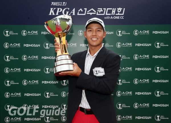 우승 재킷을 입고 우승컵을 잡은 채 환하게 웃으며 포즈를 취한 문도엽