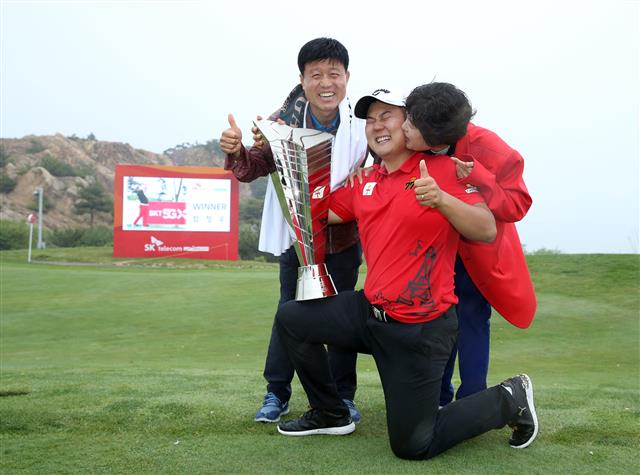 19일 인천 영종도 SKY72GC 하늘코스에서 열린 KPGA 투어 'SK텔레콤 오픈'서 우승한 함정우가 트로피를 들고 부모님과 기쁨을 나누고 있다.(사진 제공: SK 텔레콤)